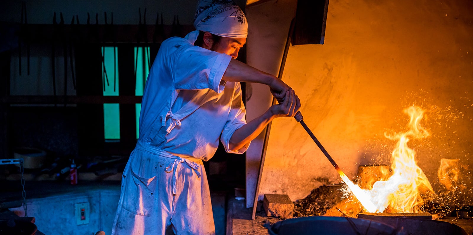Artigiano giapponese che forgia una lama di katana a mano